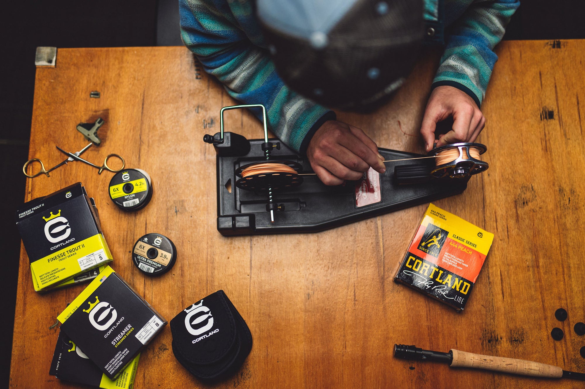 An angler setting up his fly fishing reel with various Cortland Line products