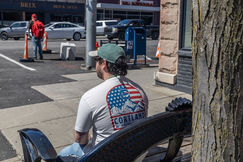 A man is sitting on a bench with his back towards the camera