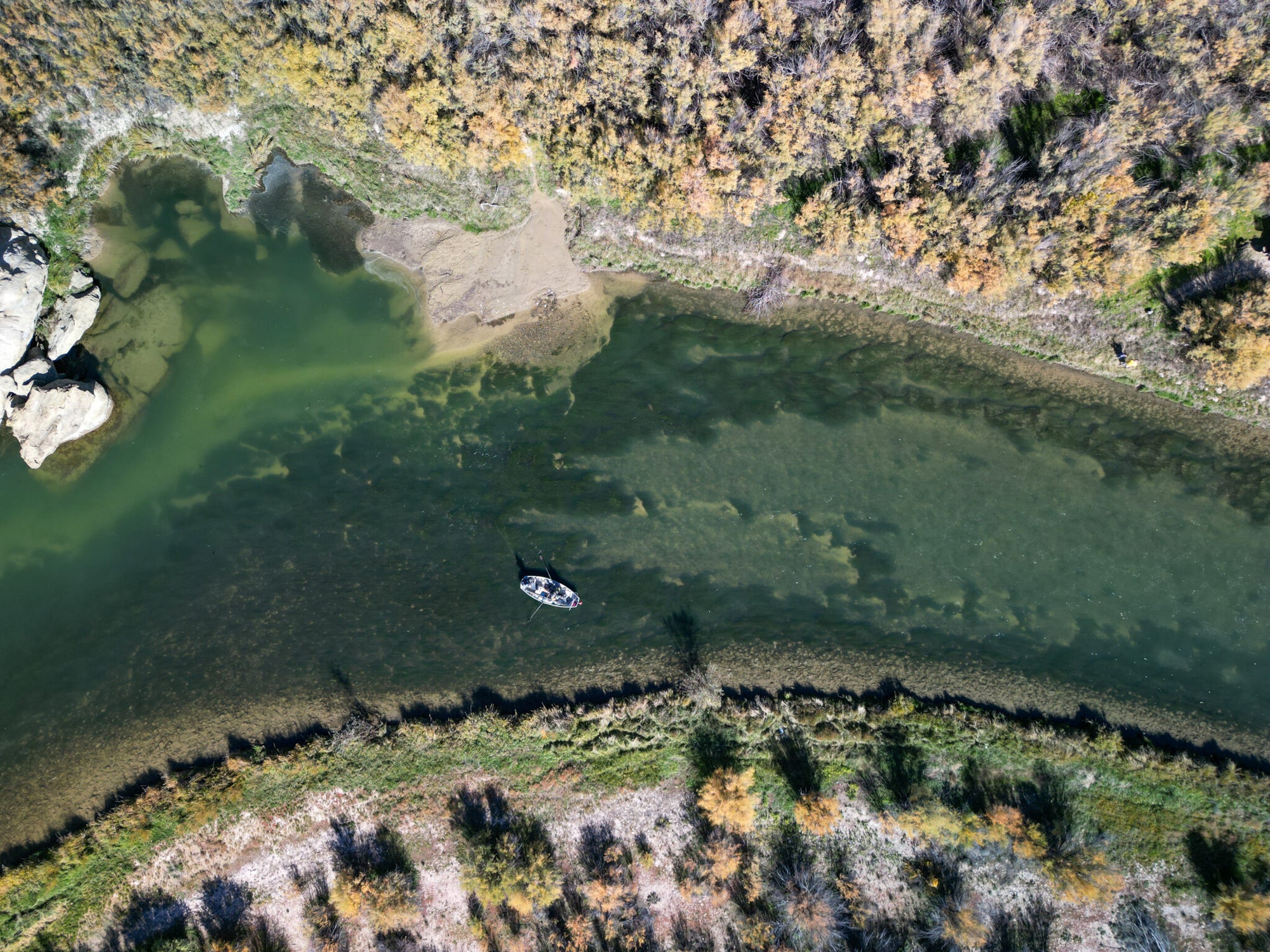 Boat on a lake surrounded by forest with autumn colors